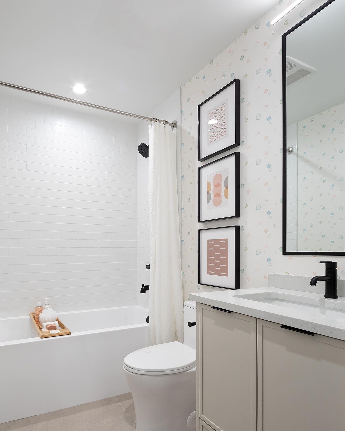This photo is from one of our recent projects Heath by @bmgroupintl 40 boutique  family townhomes in Langley. Pictured here is the main bath which includes a slim painted shaker door and black accents. The playful wallpaper and art define it as the kid's  bath.

#area3 #area3design #heath #heathlangley #modernfamilytownhome  #modernfamilytownhomedesign #washroomdesign #vanitydesign #modernshakerdoor #sunrisekitchens #blackframedmirror #Deltaplumbing #blackaccents #blackplumbing